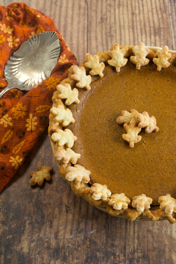 A perfect pumpkin pie with decorative pastry leaves around the edges.