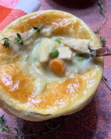 Creamy Chicken Pot Pie with a puff pastry top in a white ramekin.