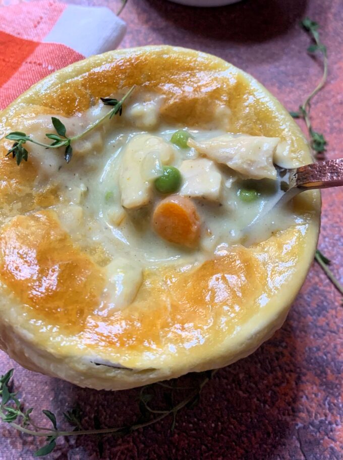 Creamy Chicken Pot Pie with a puff pastry top in a white ramekin.
