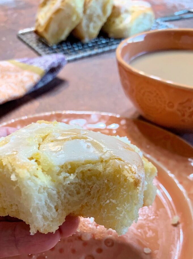 A soft and fluffy Overnight Orange Sweet Roll with a bite out of it.