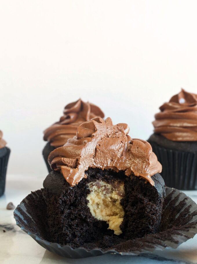 A dark chocolate cupcake with a cookie dough center and whipped chocolate ganache frosting.
