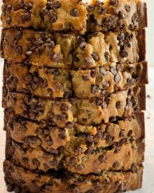 A sliced loaf of chocolate chip banana bread standing vertically on one end.