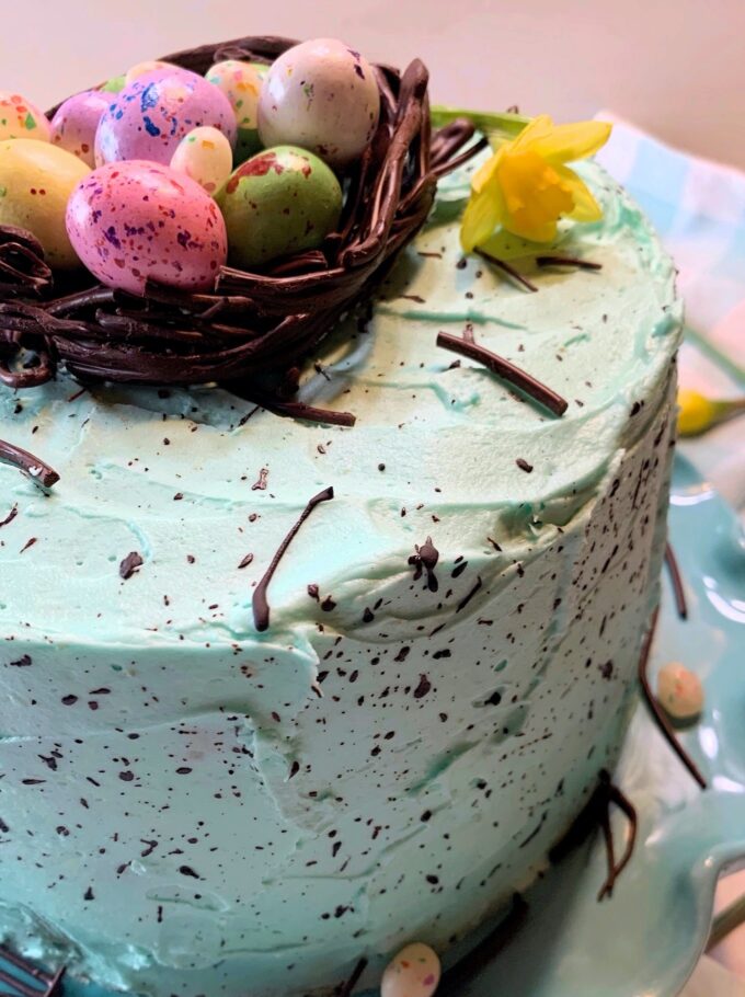 A speckled Easter cake with a chocolate nest on top full of candy eggs.
