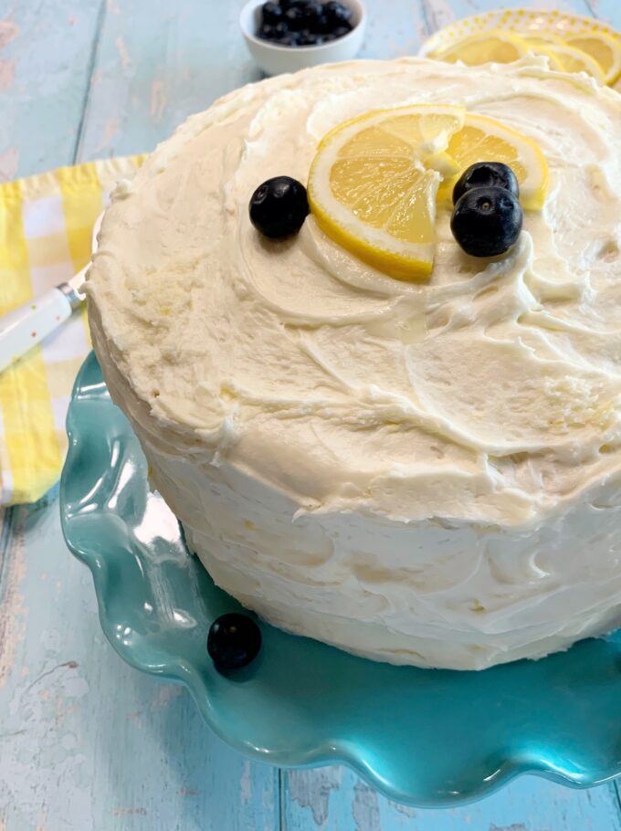A Lemon Blueberry Cake with lemon and blueberries on top.