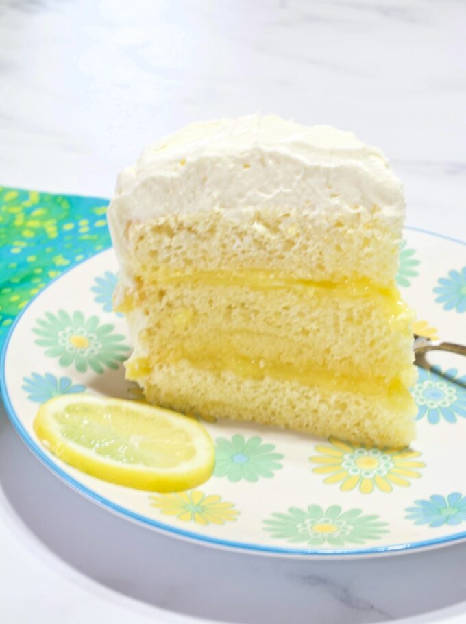 A slice of Lemon Chiffon Layer Cake on a plate.