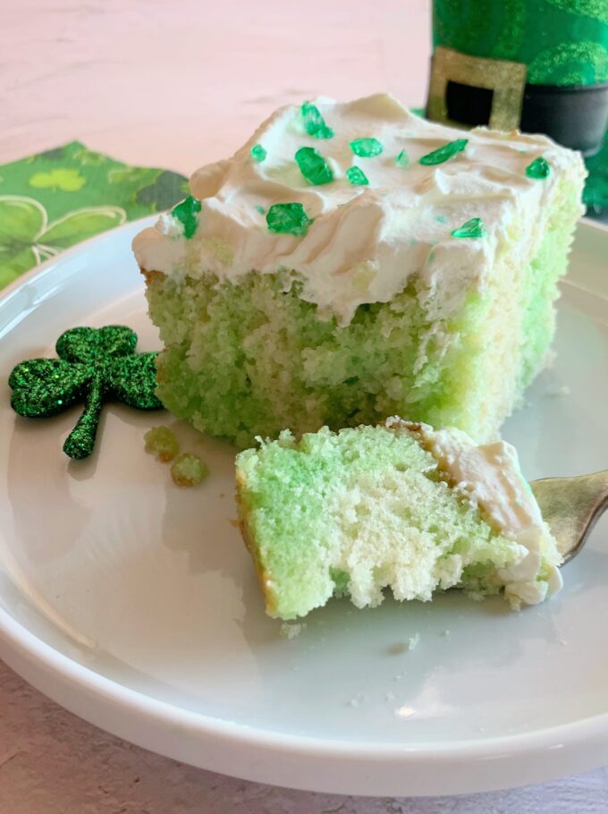 A piece of Buttermilk Lime Poke Cake on a white plate.