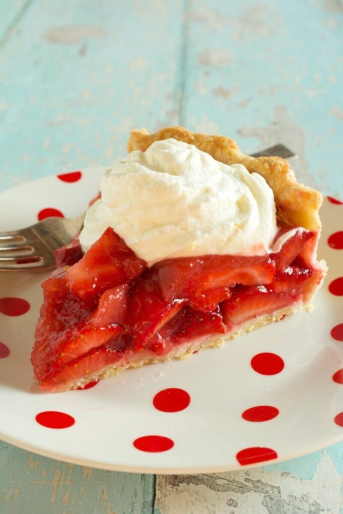 A slice of Strawberry Glaze Pie on a red and white dessert plate.