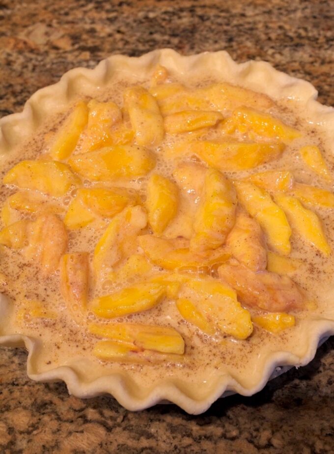An unbaked peached and cream pie.