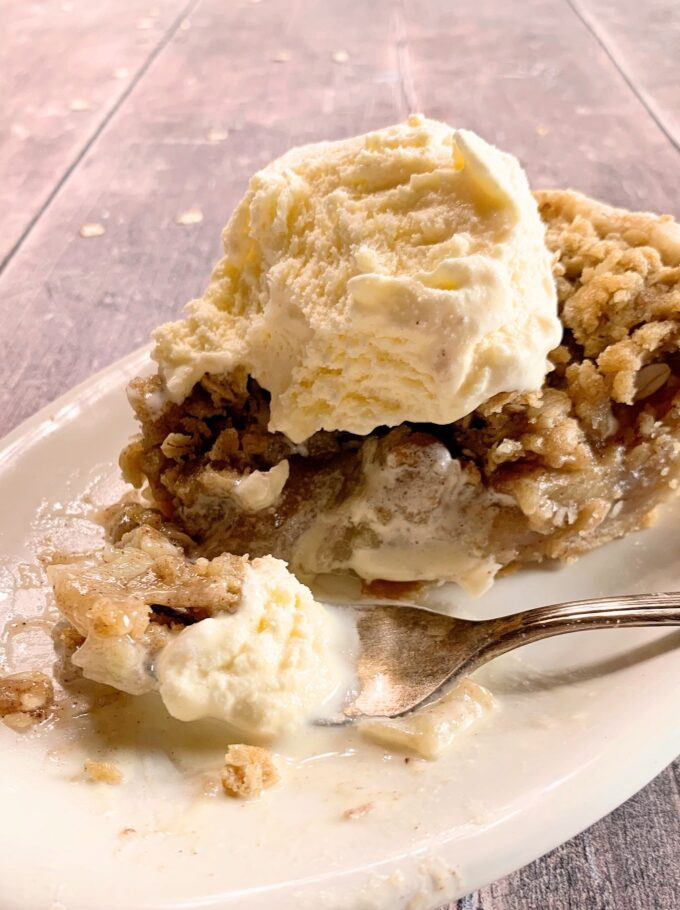 A slice of apple pie with ice cream.