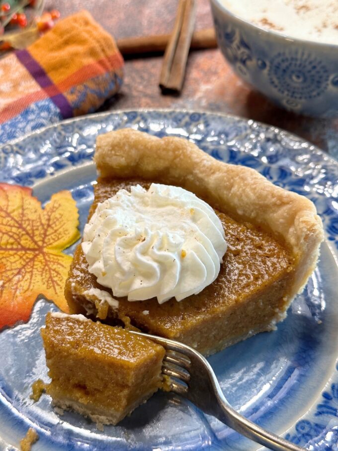 A slice of pumpkin chess pie with a forked bite.