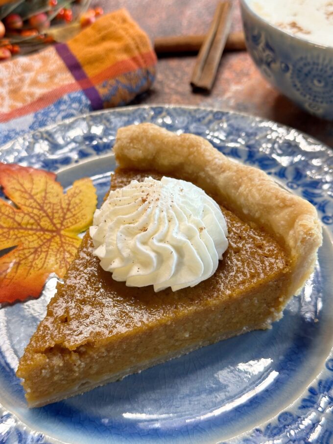 A slice of pumpkin chess pie topped with whipped cream.