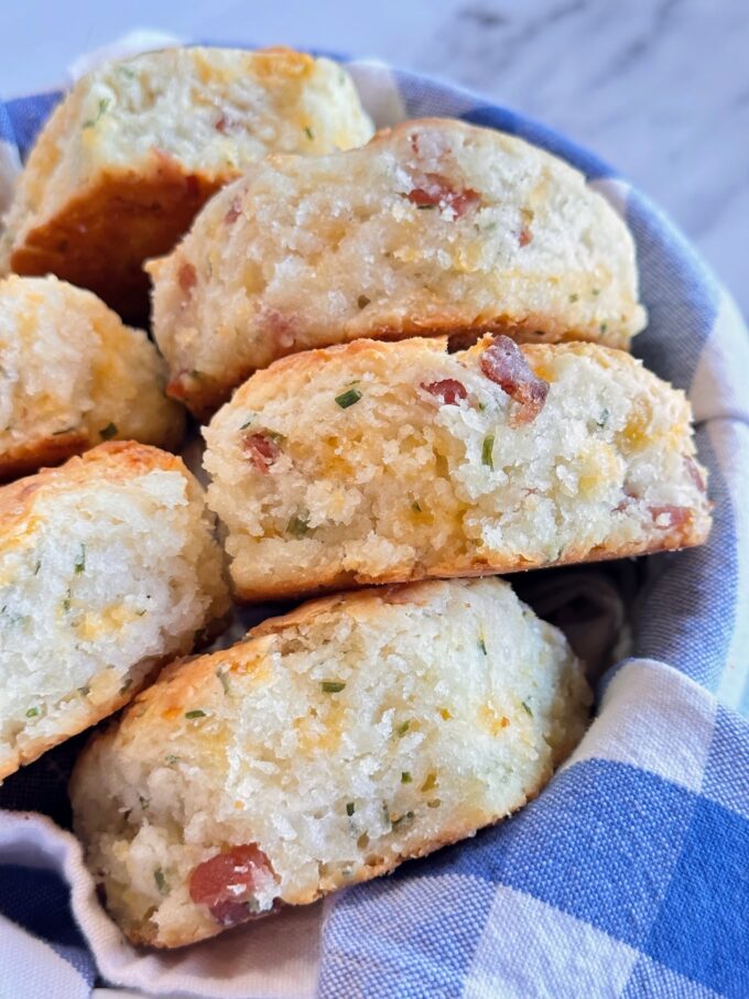 A basket of bacon cheddar and chives biscuits.